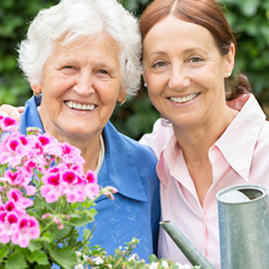 Senior woman and middle-aged woman gardening and smiling